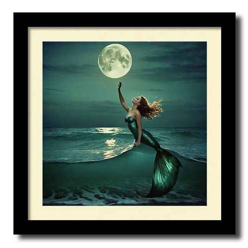 Digital artwork framed print of a mermaid with flowing hair reaches out towards a glowing full moon as she emerges from the ocean waves