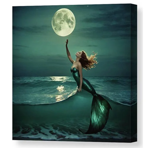 Digital artwork canvas print of a mermaid with flowing hair reaches out towards a glowing full moon as she emerges from the ocean waves.